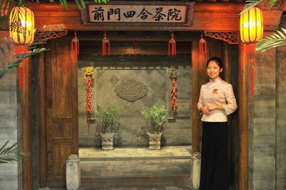 Chinesische Frau vor einem Tor © Flickr / Luo Shaoyang